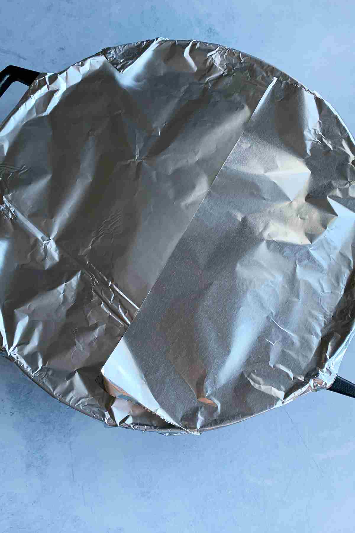 Cast iron skillet covered with aluminum foil.