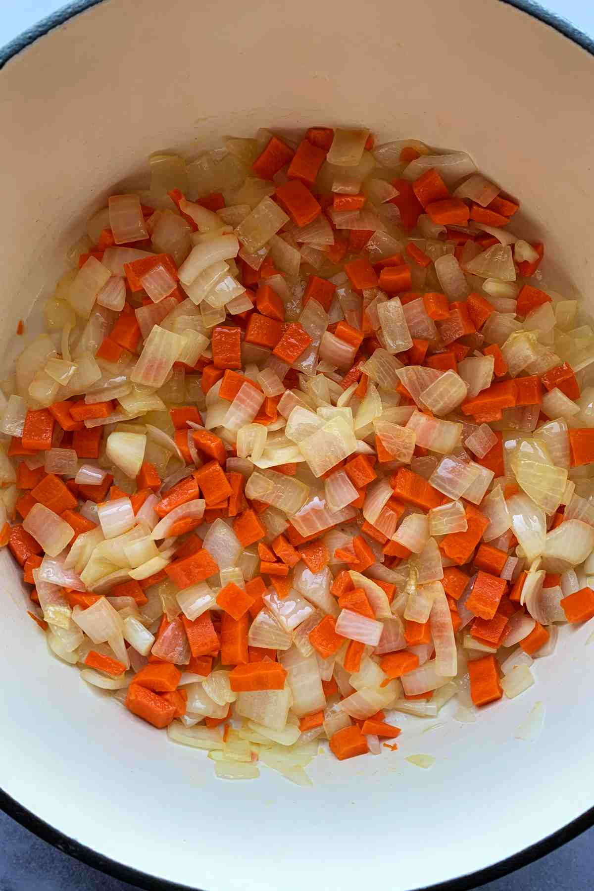 Chopped onion and carrots in a pot.