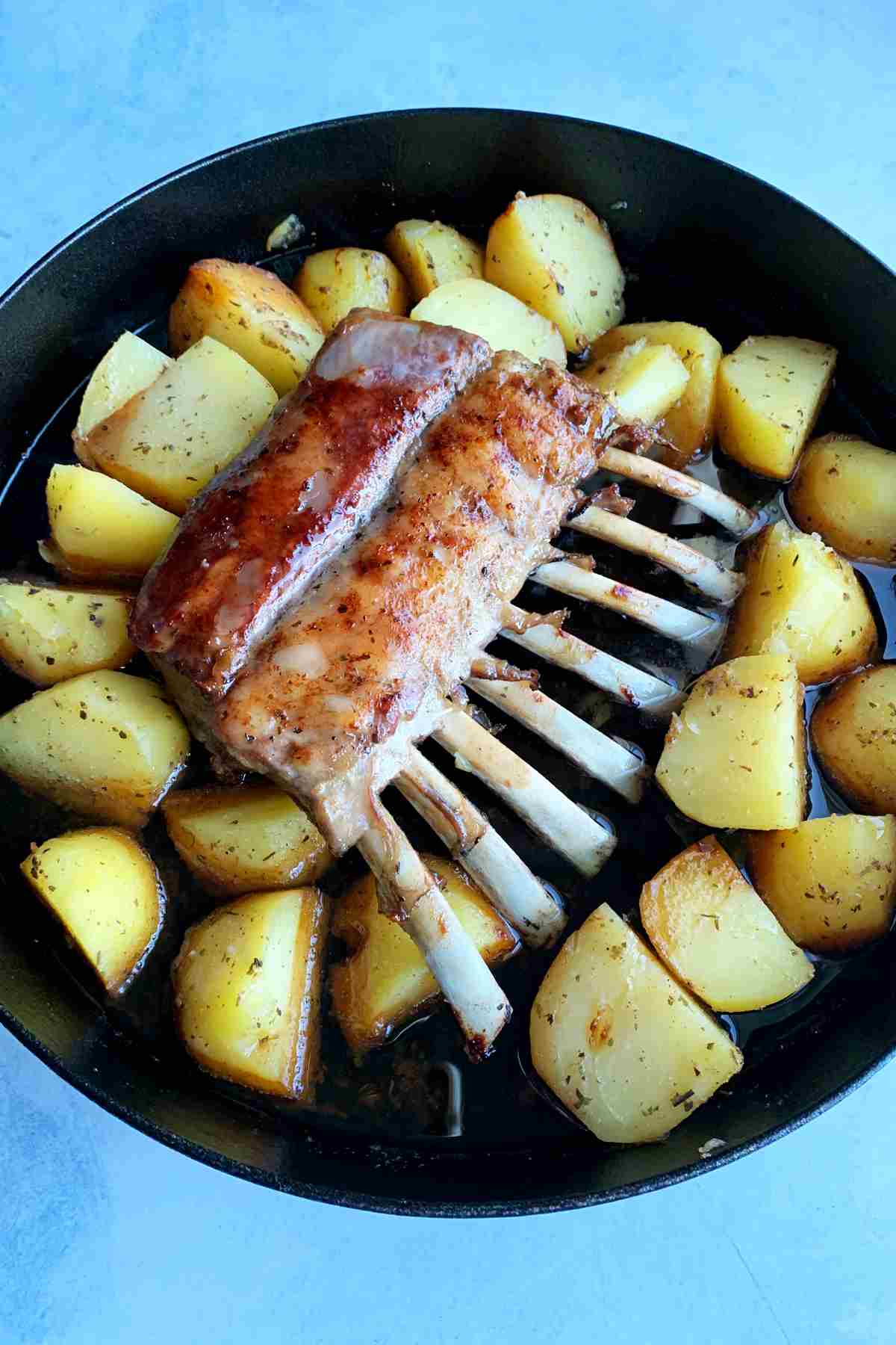 Baking lamb ribs with cut potatoes.
