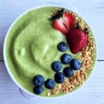 Green smoothie bowl with toppings overhead.