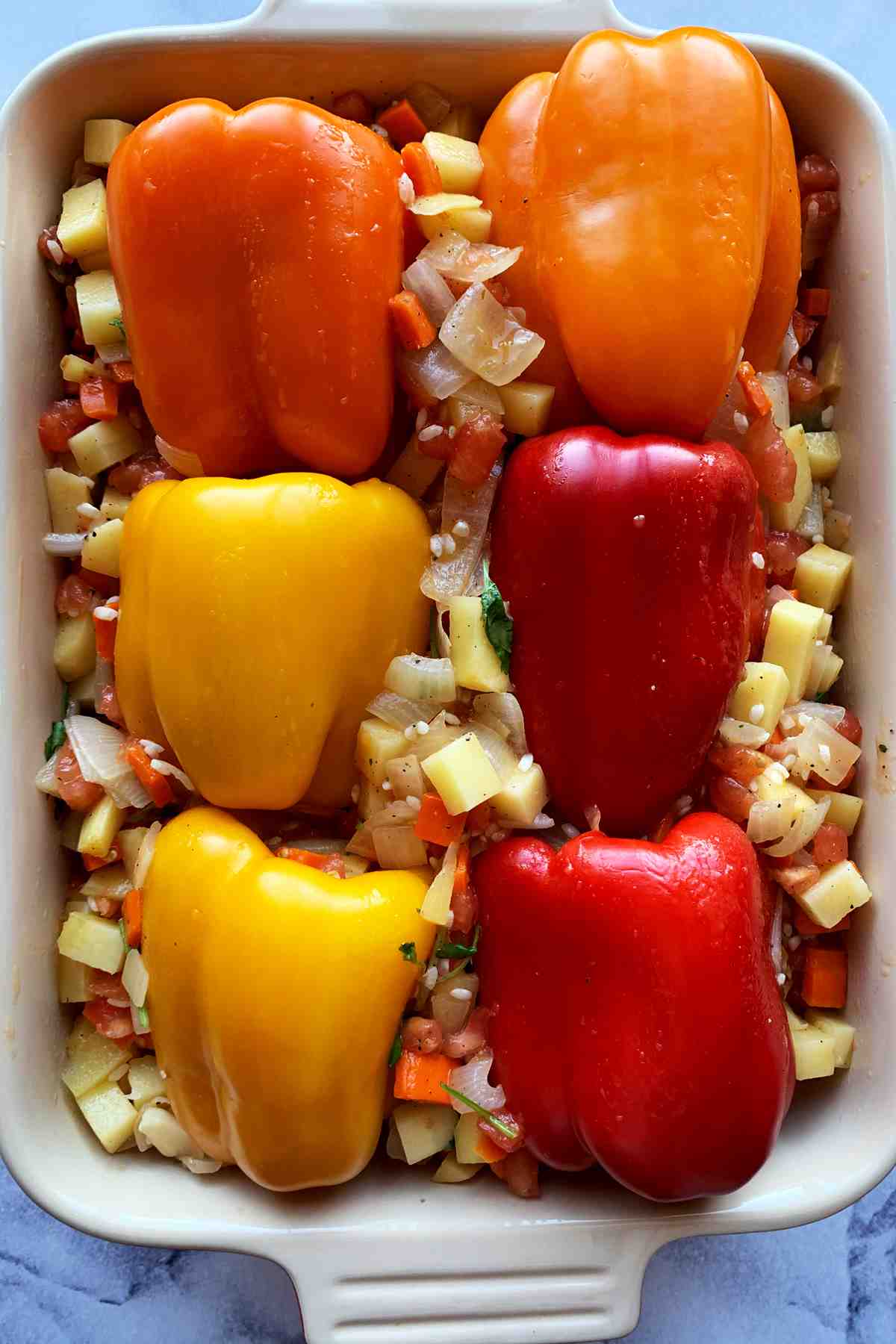 Stuffed bell peppers in a baking dish ready to bake.