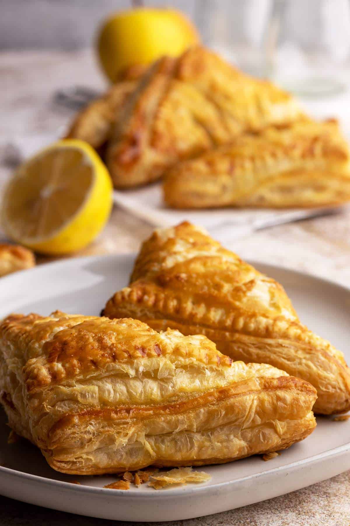 Apple turnovers with flaky puff pastry on a plate.
