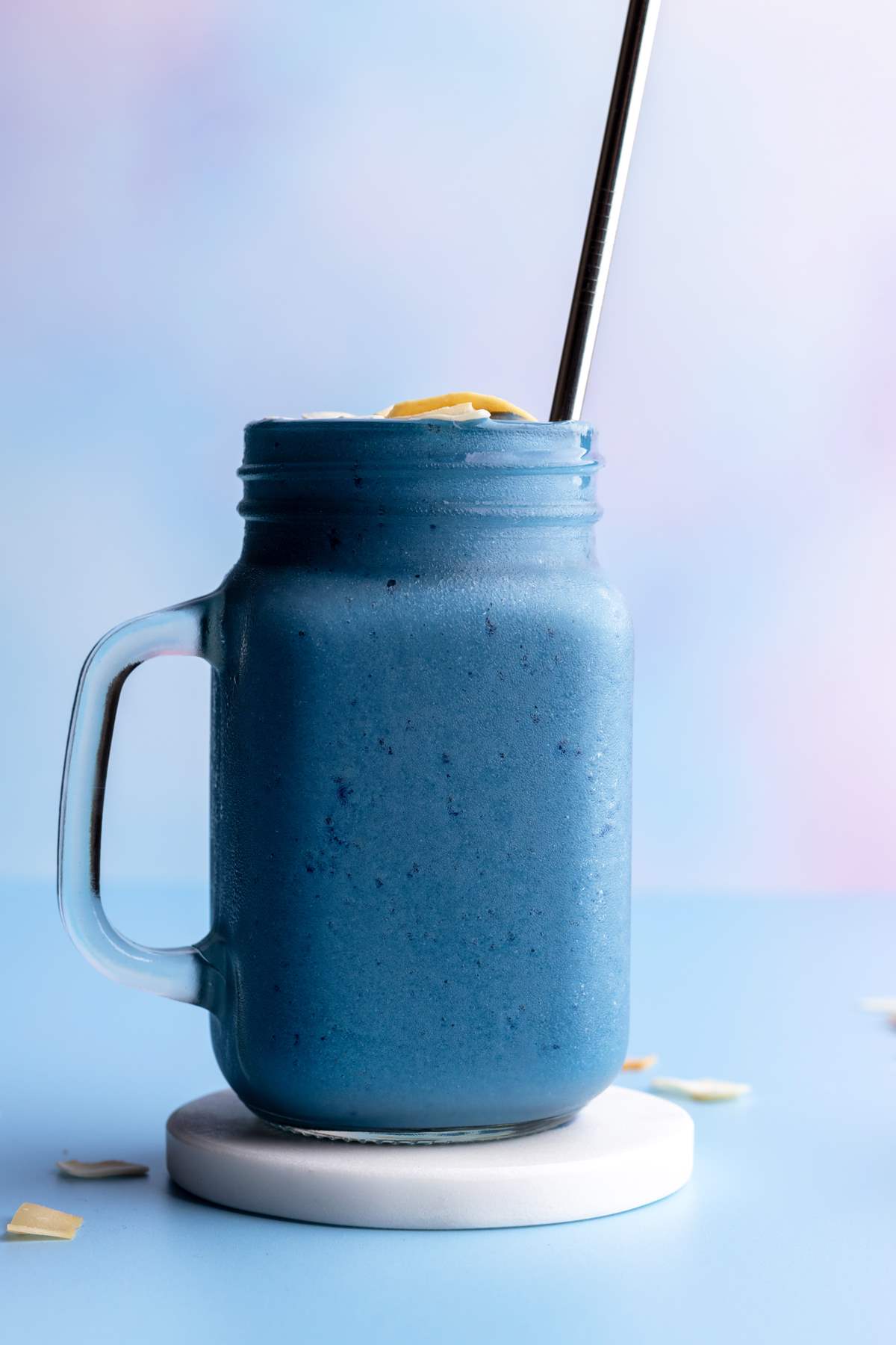 Blue spirulina smoothie in a jar with straw.