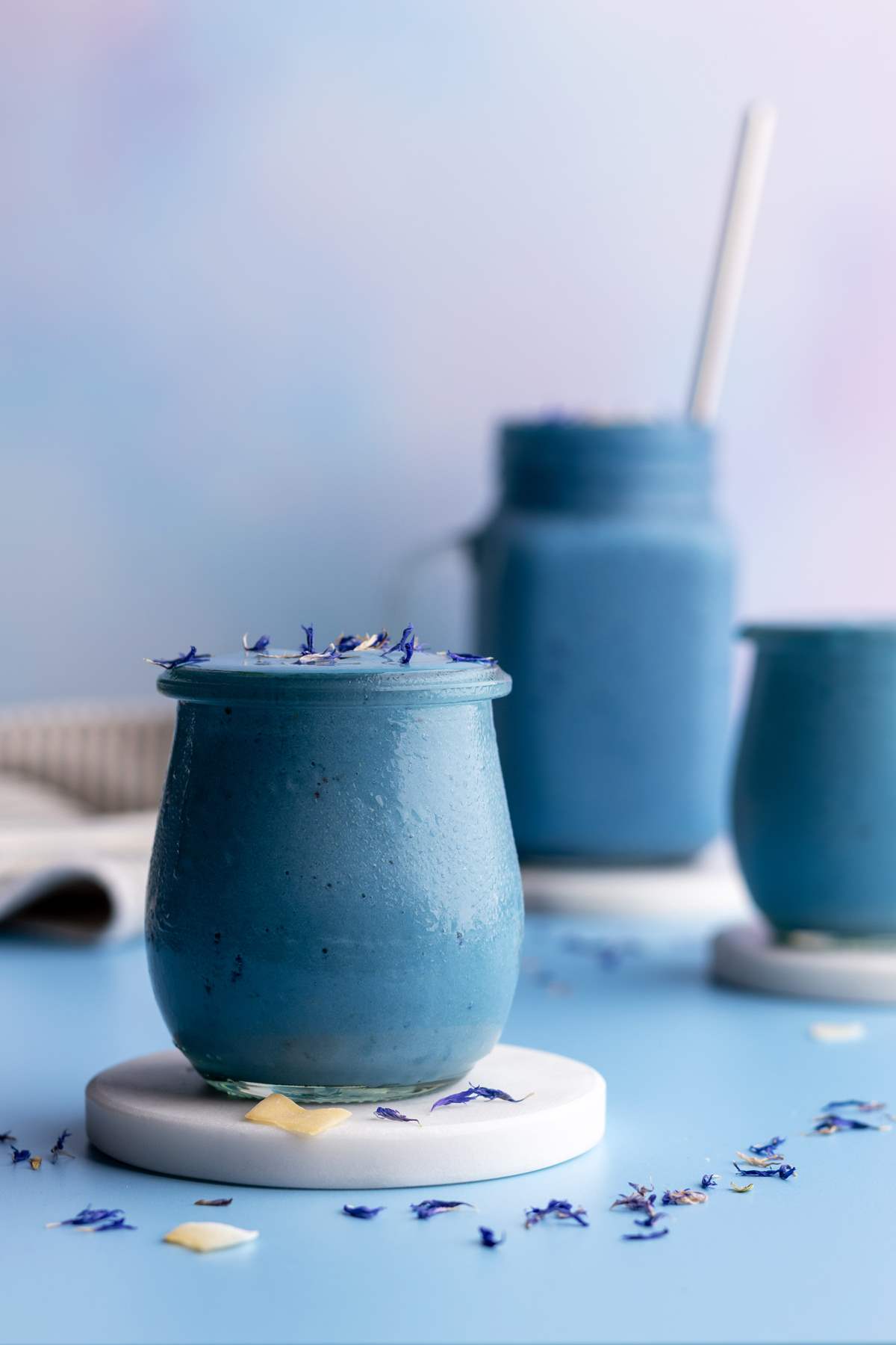 Blue spirulina smoothie in small jar closeup shot.