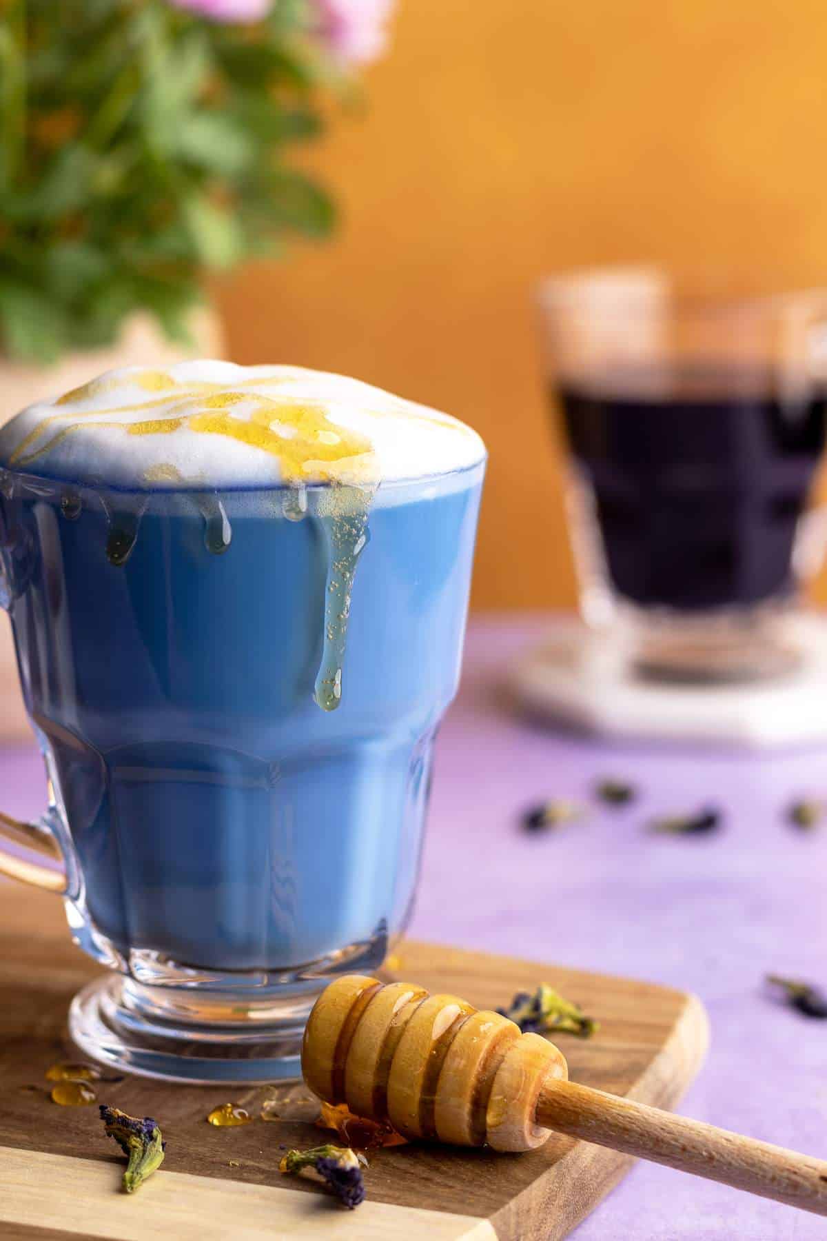 Butterfly pea flower latte with drizzled honey.