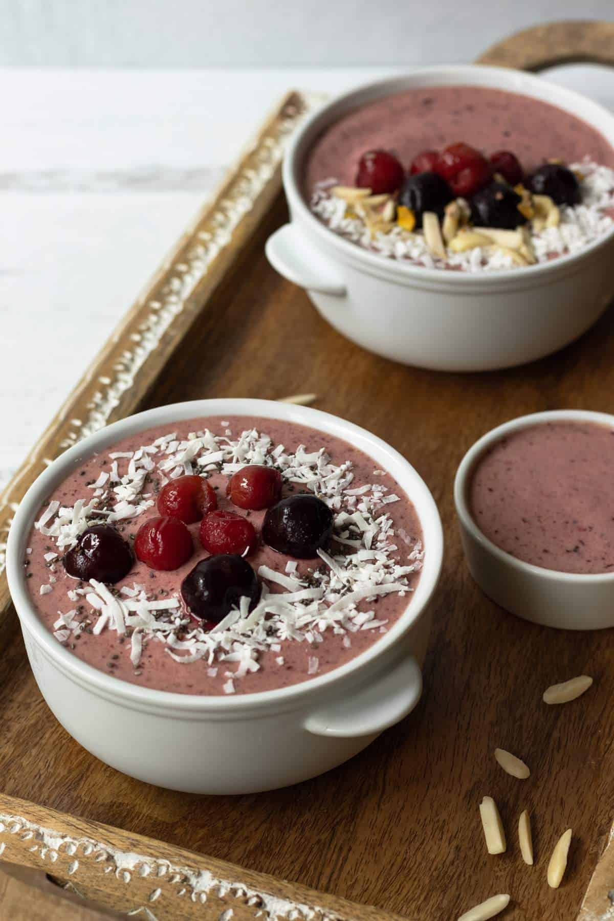 Cherry smoothie bowls in a serving tray.