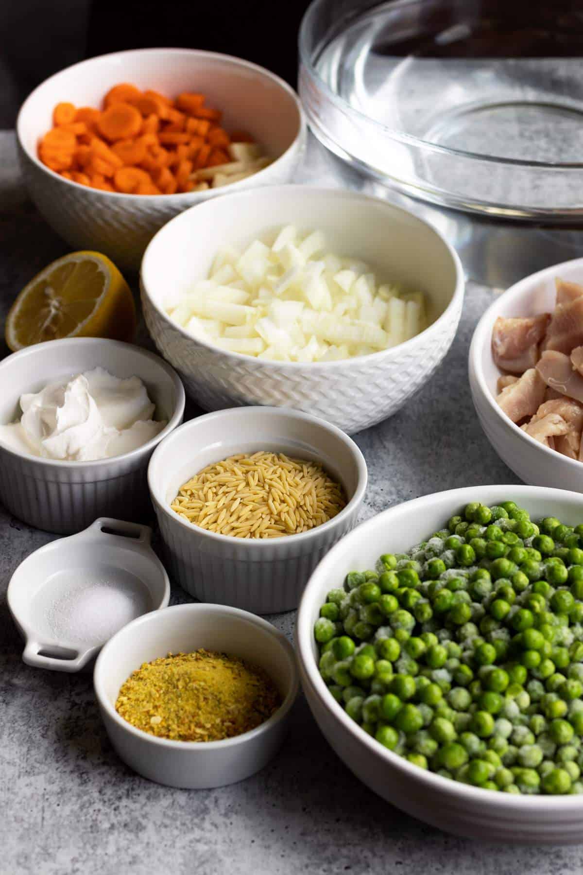 Chicken orzo soup ingredients in individual bowls.