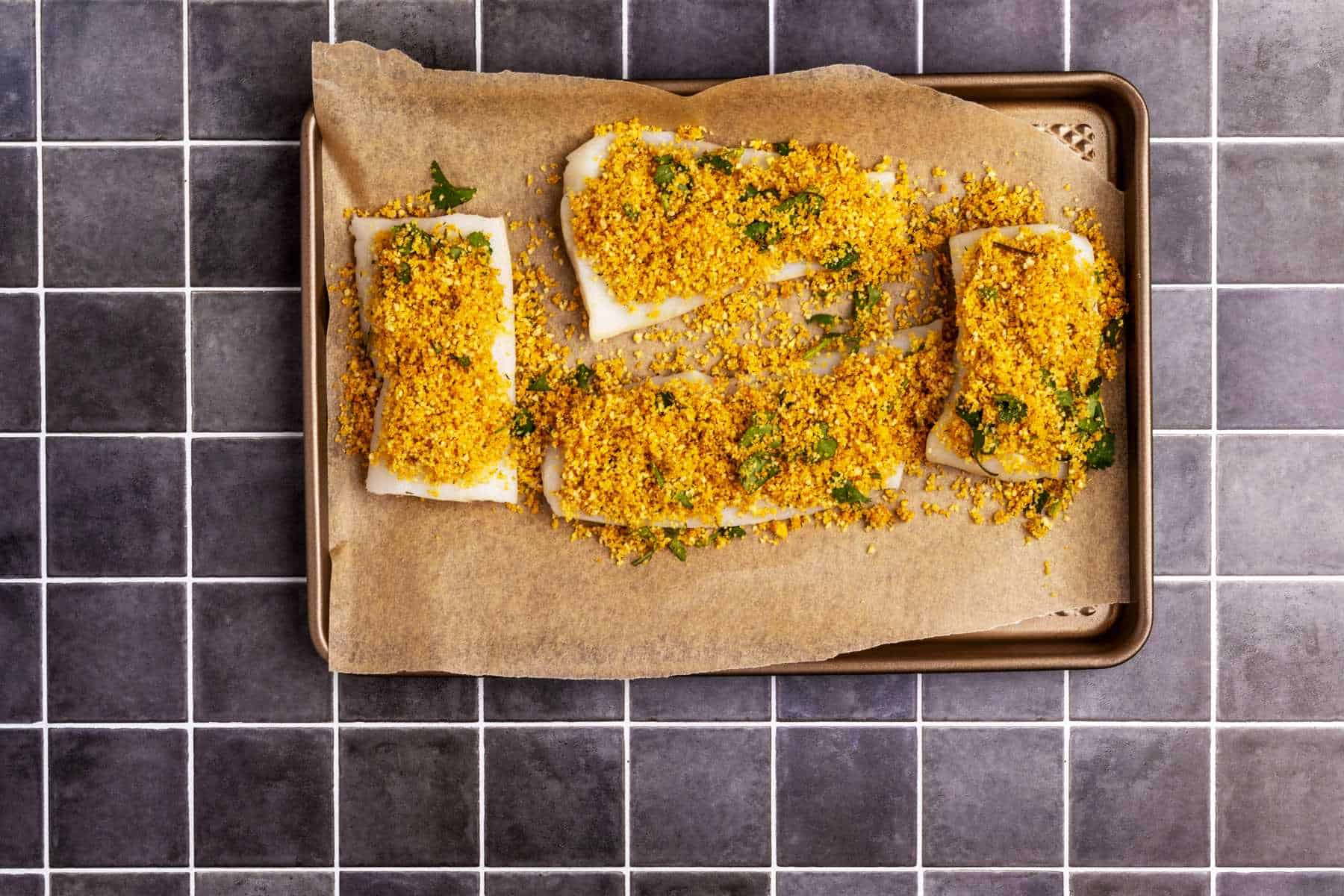 Cod with panko breadcrumbs in baking sheet.