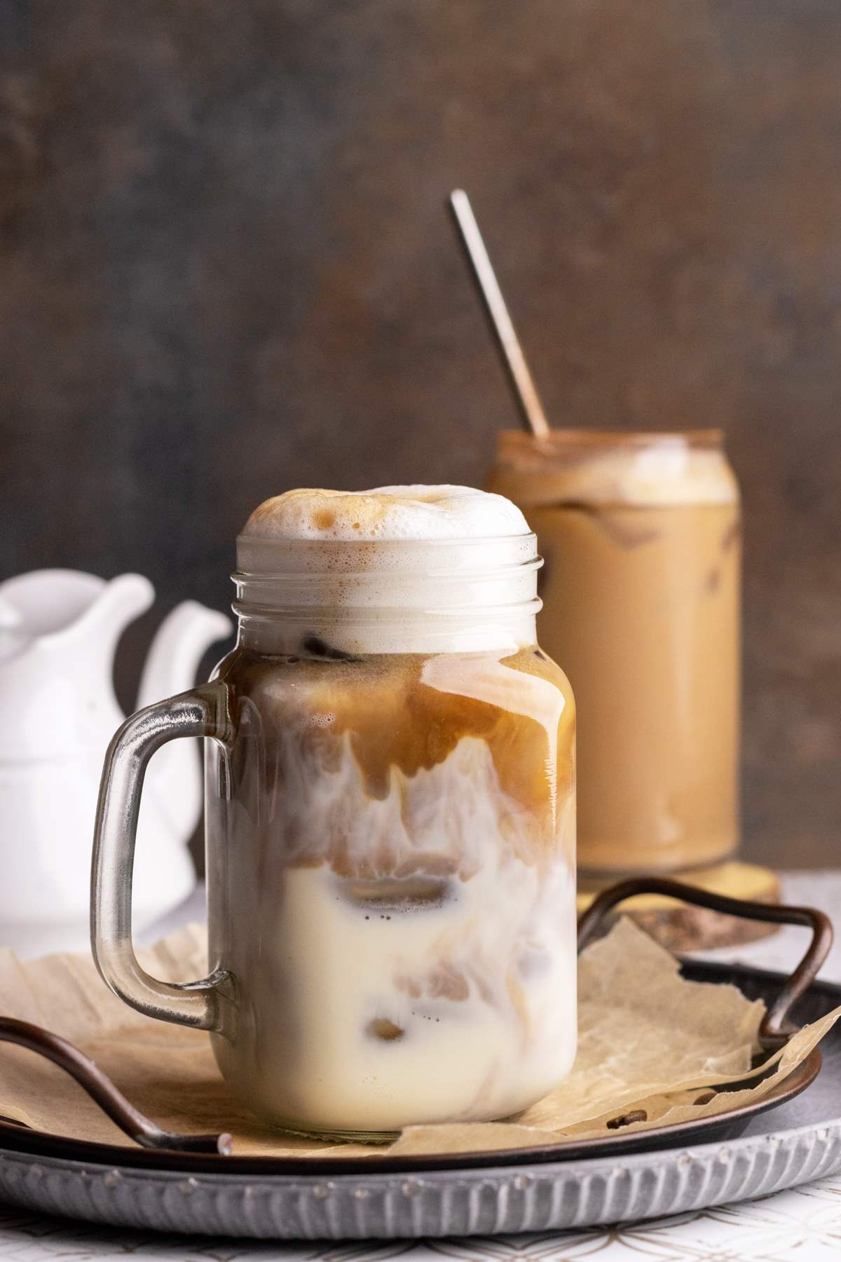 Espresso swirls in a jar with iced oat milk.