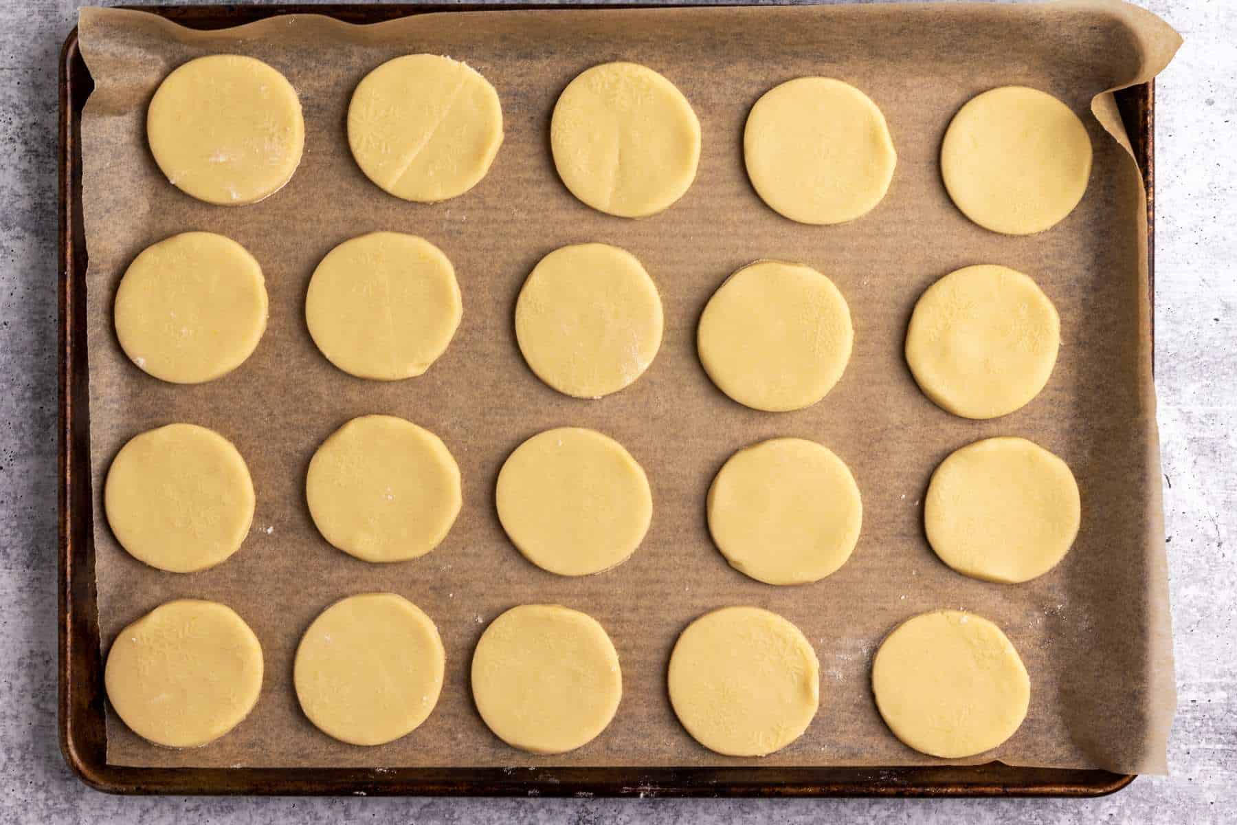 Gurabije lard cookies on a parchment-lined baking sheet.