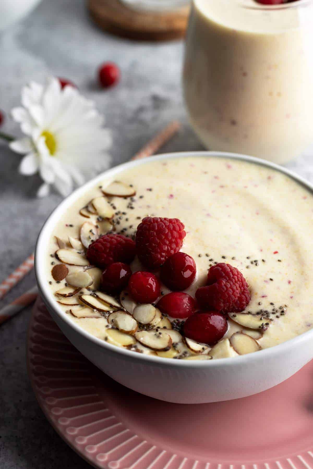 Pineapple peach smoothie in a bowl with fruit toppings.