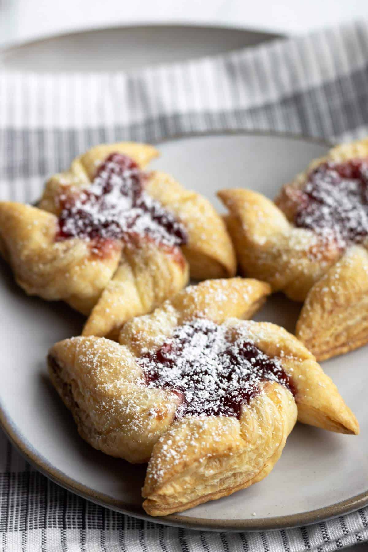 Puff pastry pinwheels with raspberry jam on a plate.
