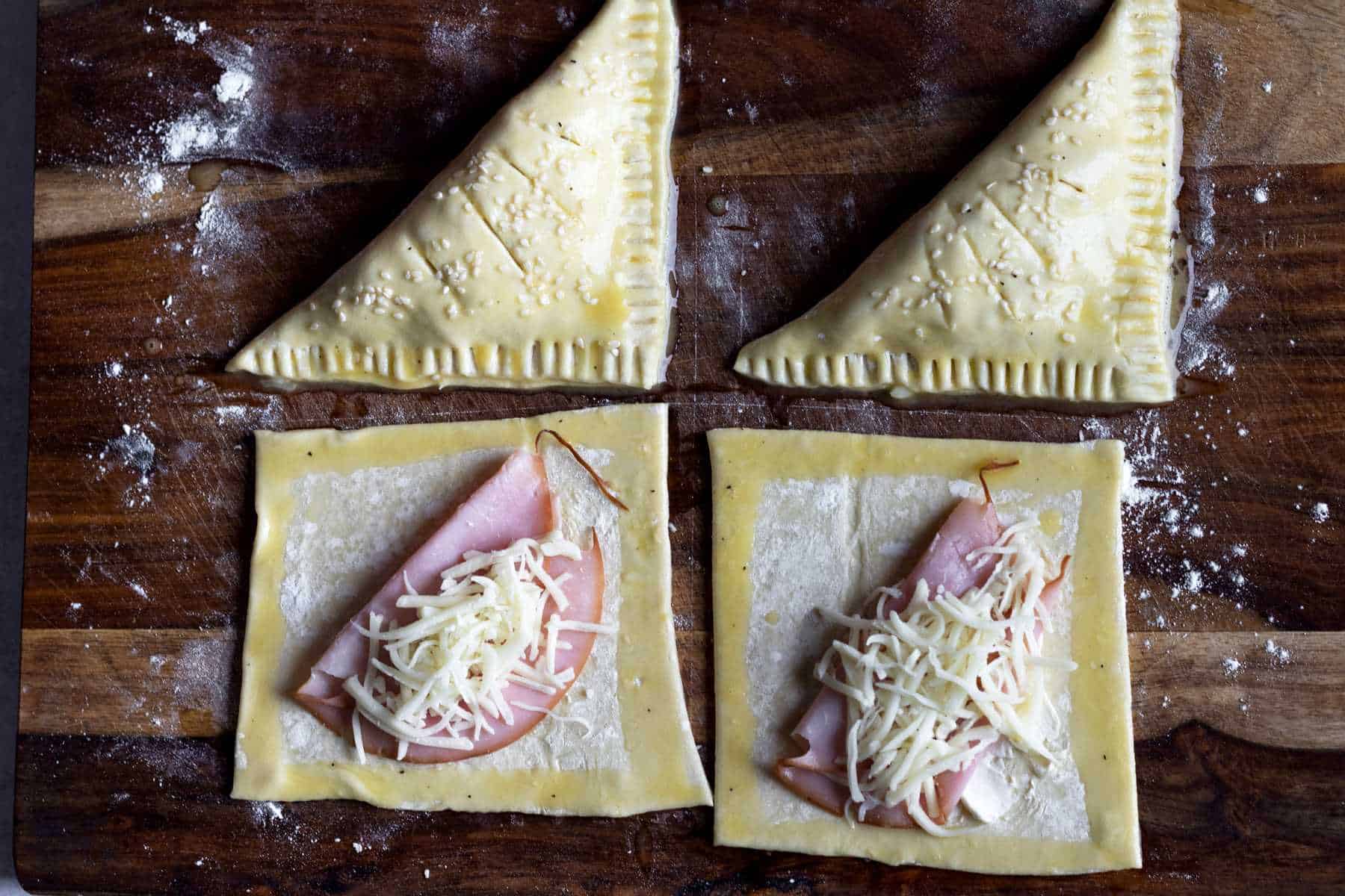 Assembling ham and cheese puff pastry turnovers.