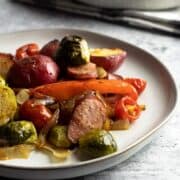 Sheet pan sausage and veggies on a plate.