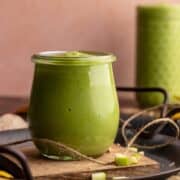 Sour apple smoothie in small jar closeup.