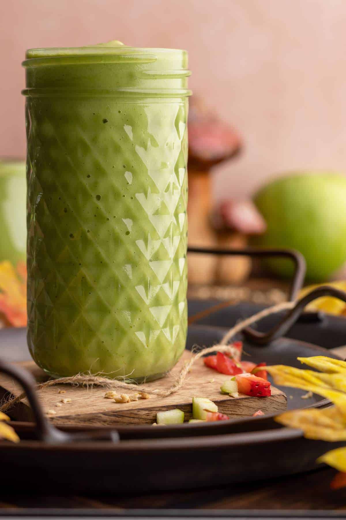 Apple banana spinach smoothie in tall jar.