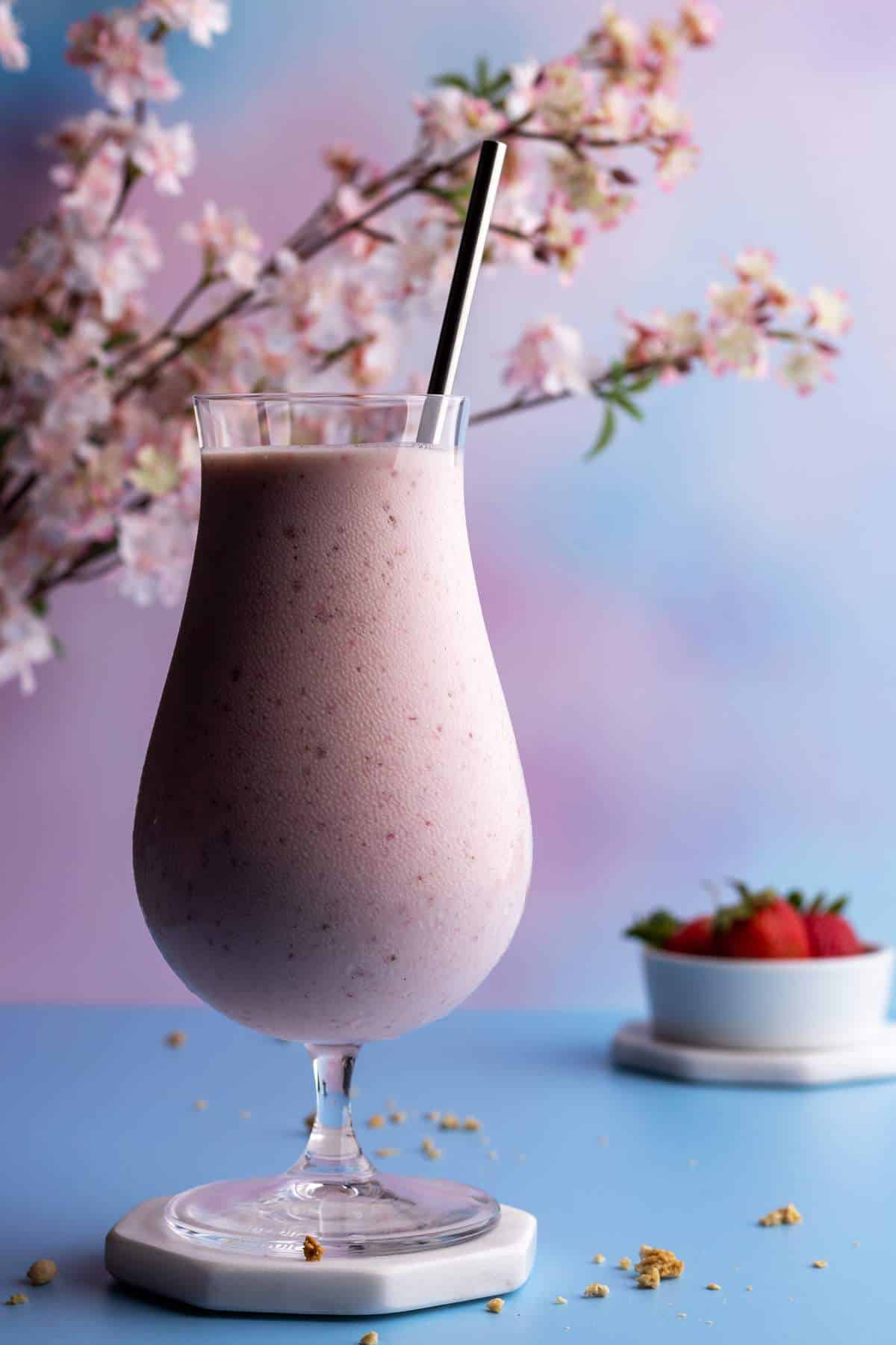 Strawberry banana milkshake in a tall glass closeup shot.
