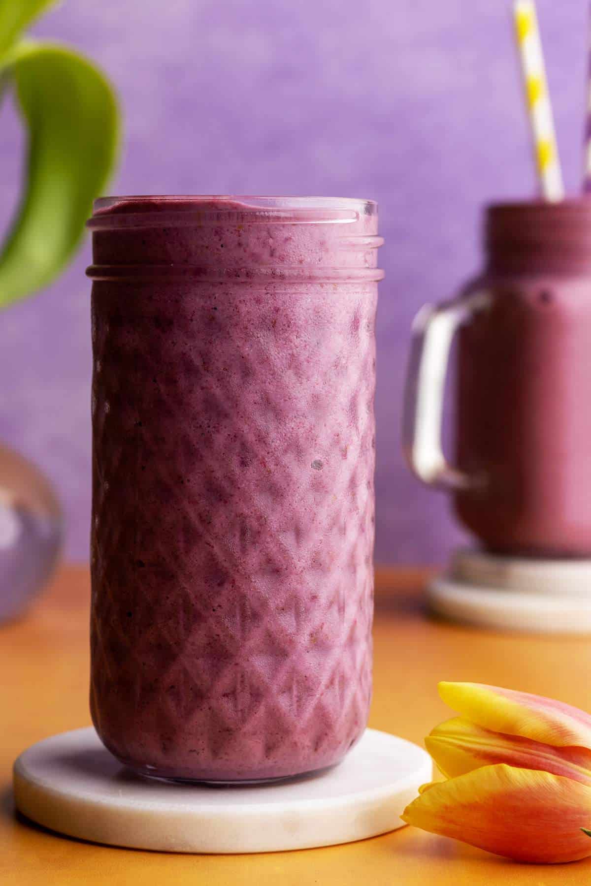Strawberry banana blackberry smoothie in a tall jar.