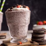 Strawberry milkshake in a glass with toppings.