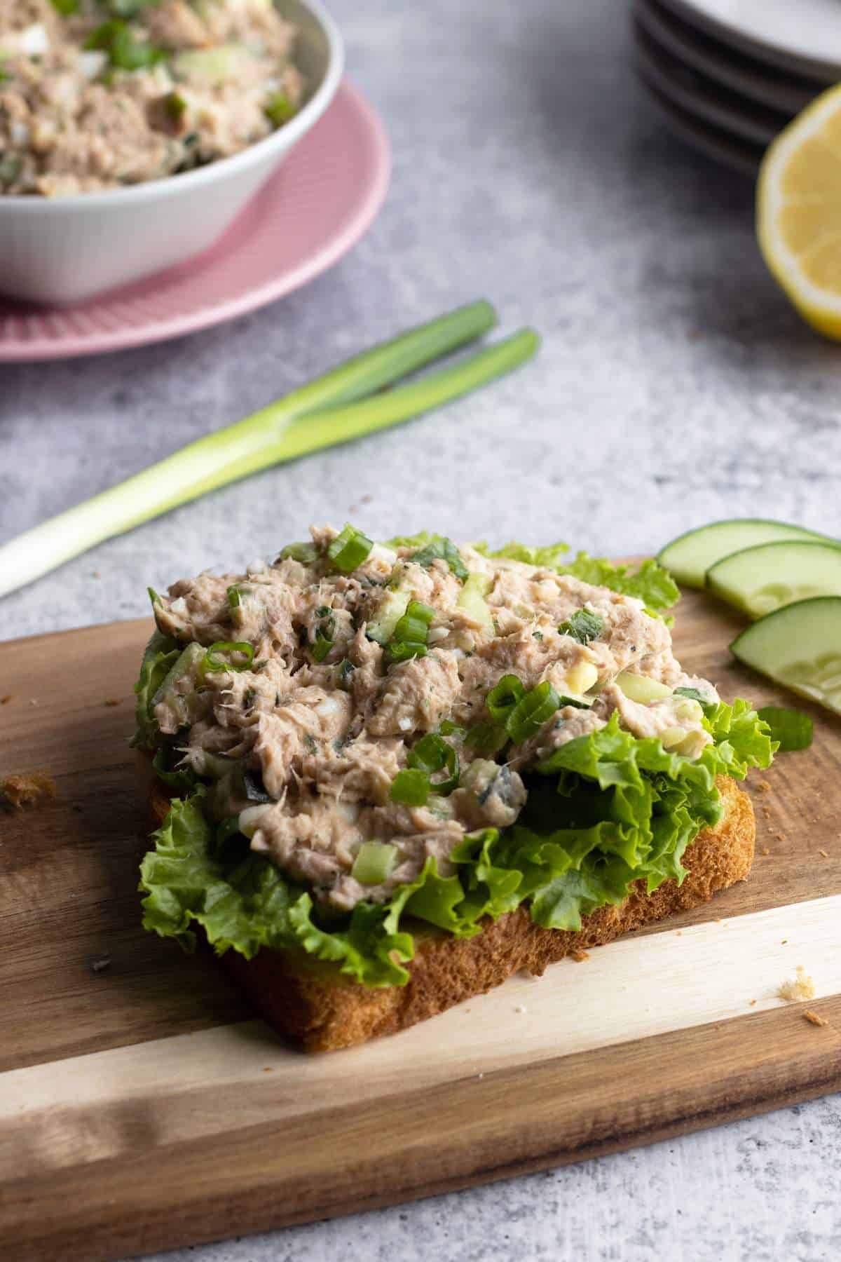 Tuna egg salad sandwich on a wooden board.