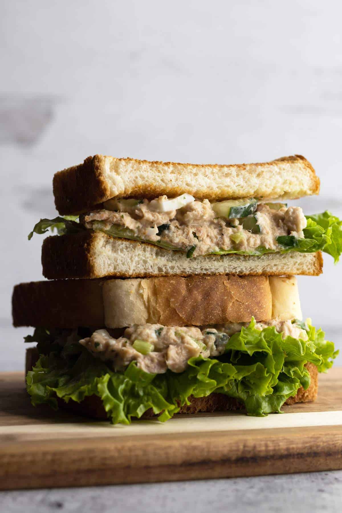 Tuna egg salad sandwich sliced and stacked.