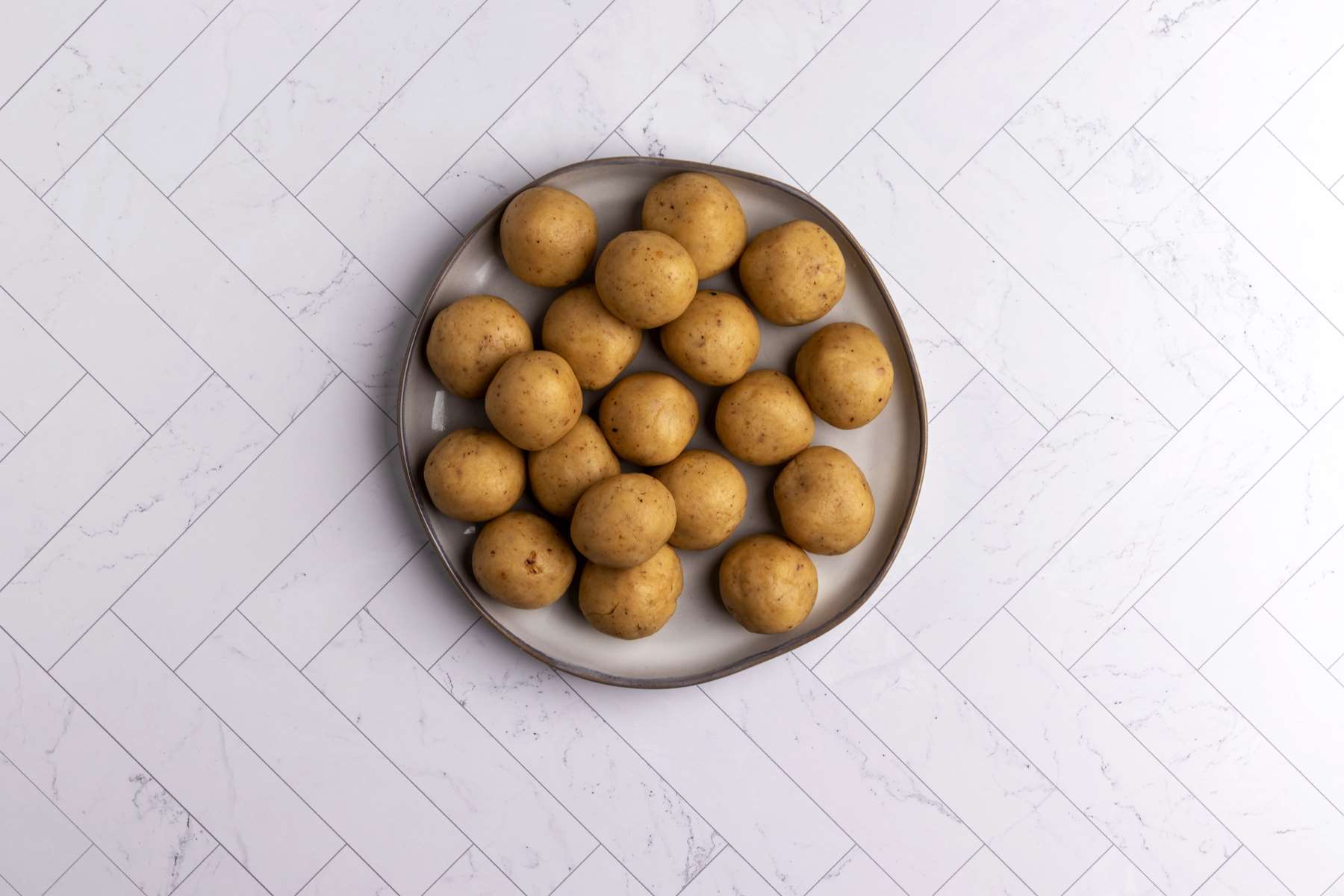Walnut cookies dough balls on a plate.