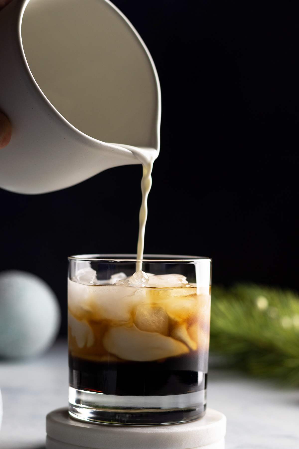 White Russian pouring the creamer into the glass.