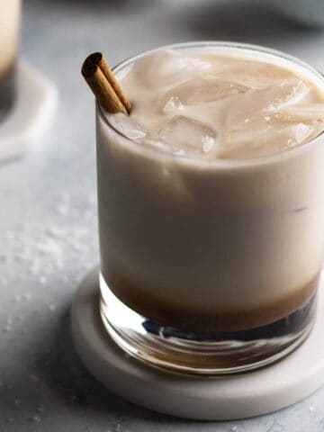 White Russian with a cinnamon stick in a glass.