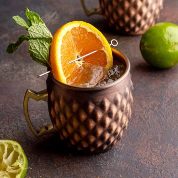 London mule in copper mug with orange wheel and mint leaves.