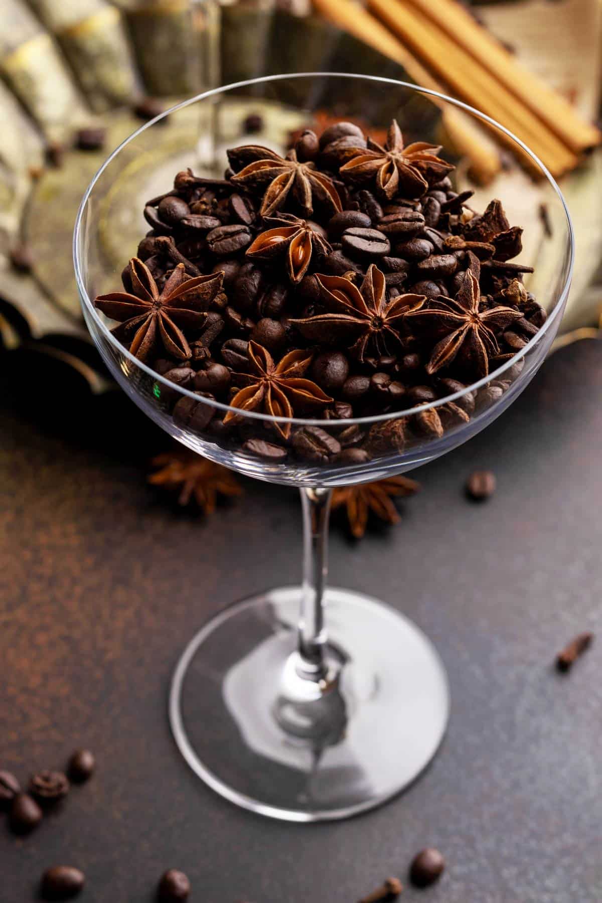 Coffee beans and star anise in a glass.