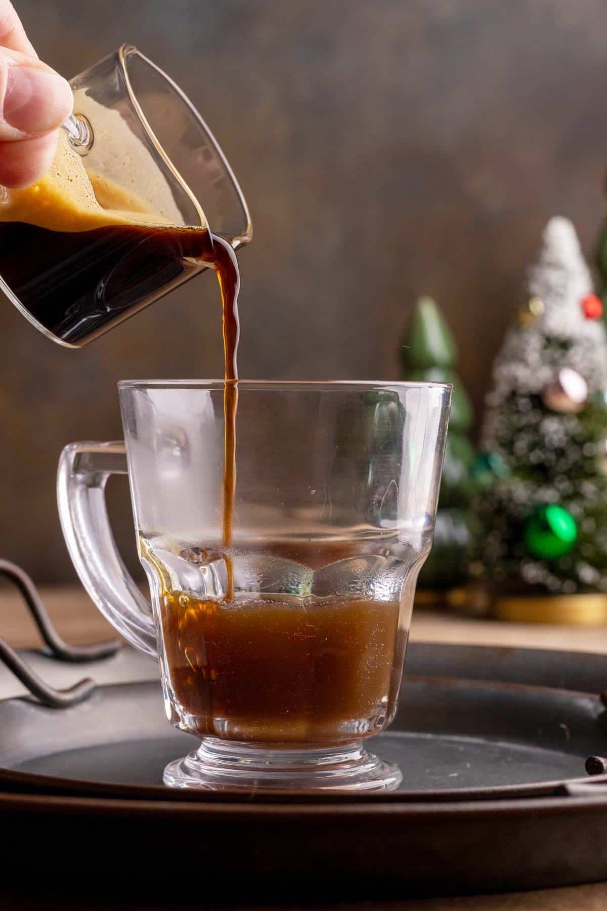 Pouring espresso into a mug with chai.