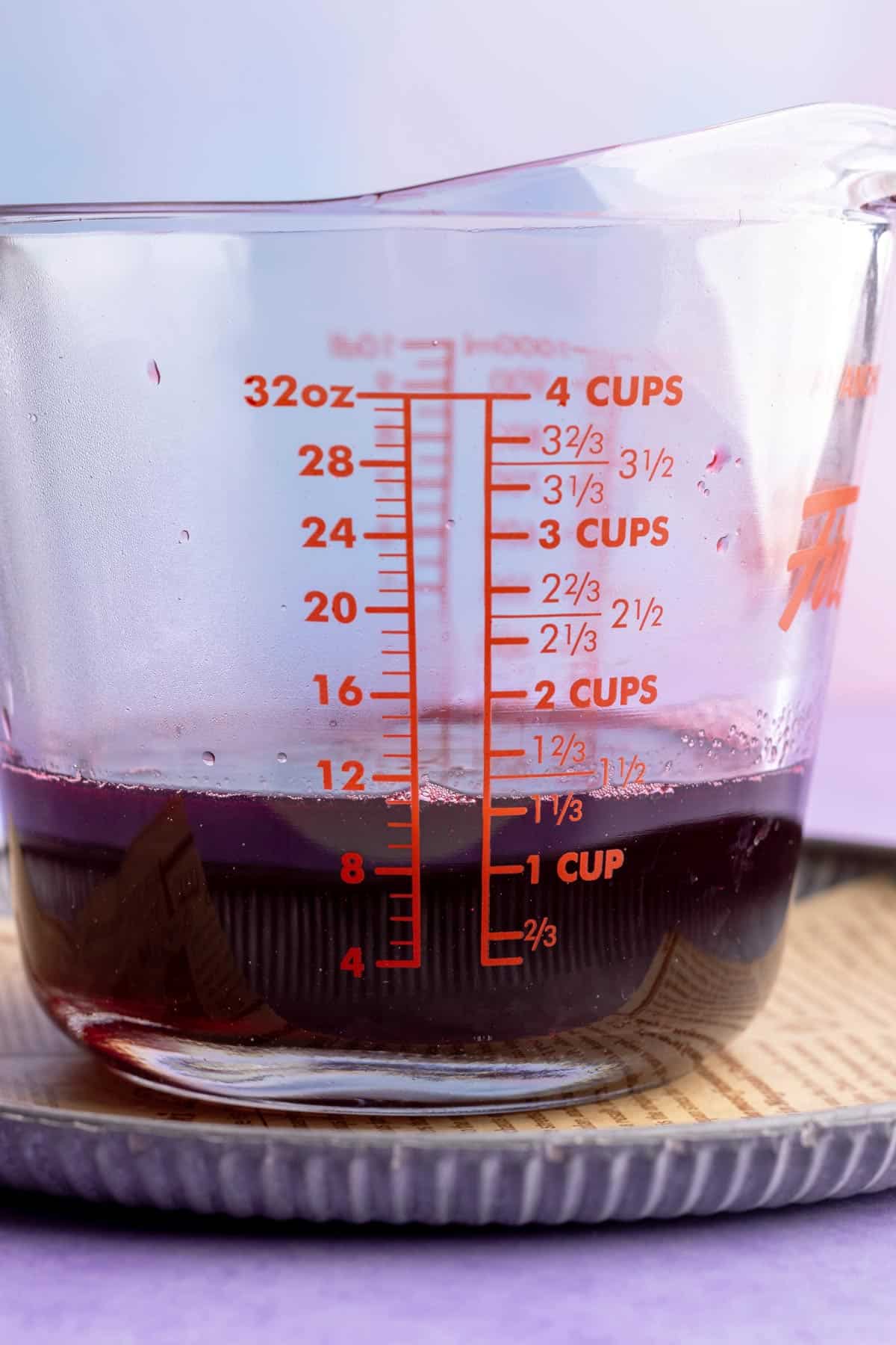 Blackberry simple syrup in measuring bowl.
