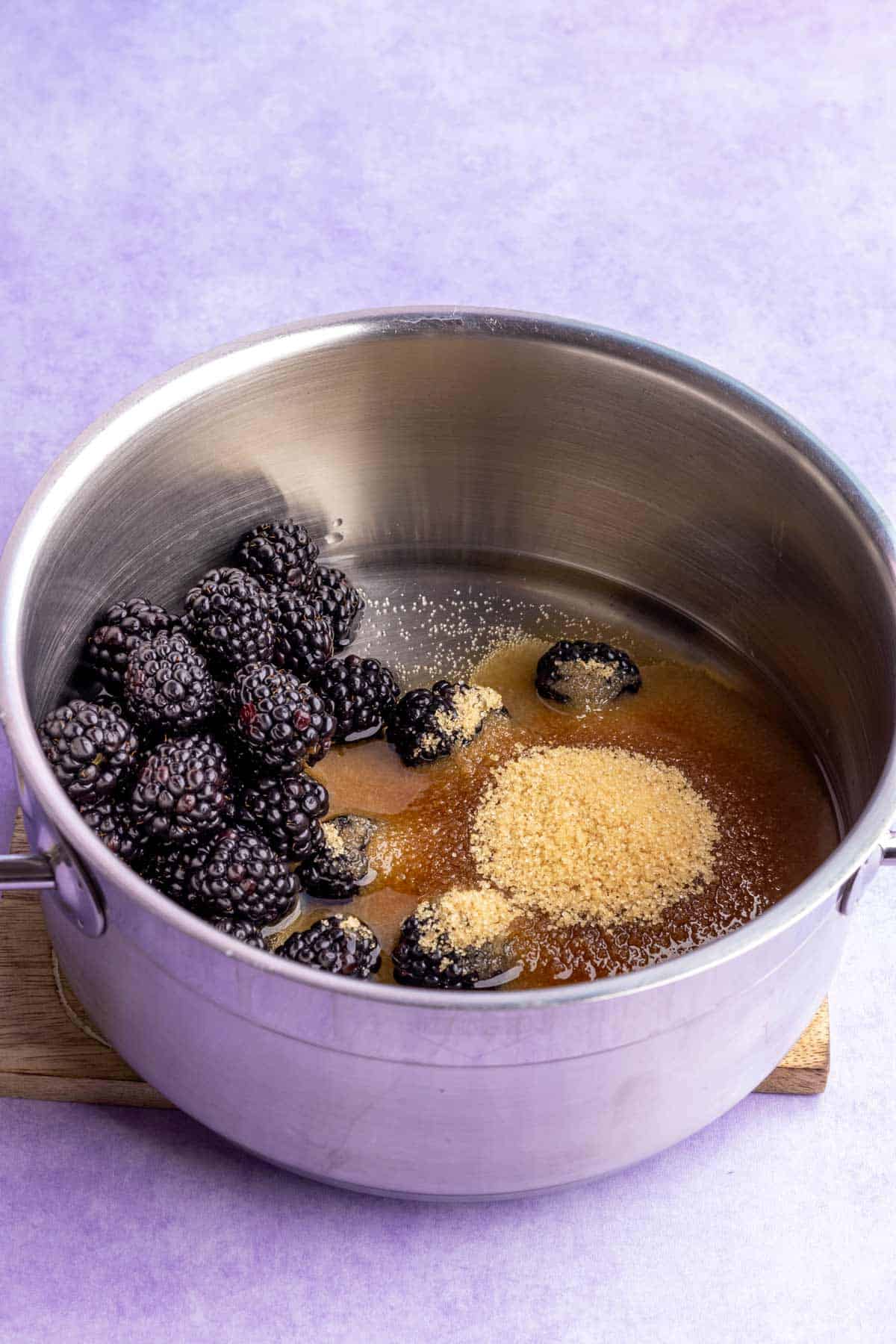 Blackberries, brown sugar, and water added to a pot.