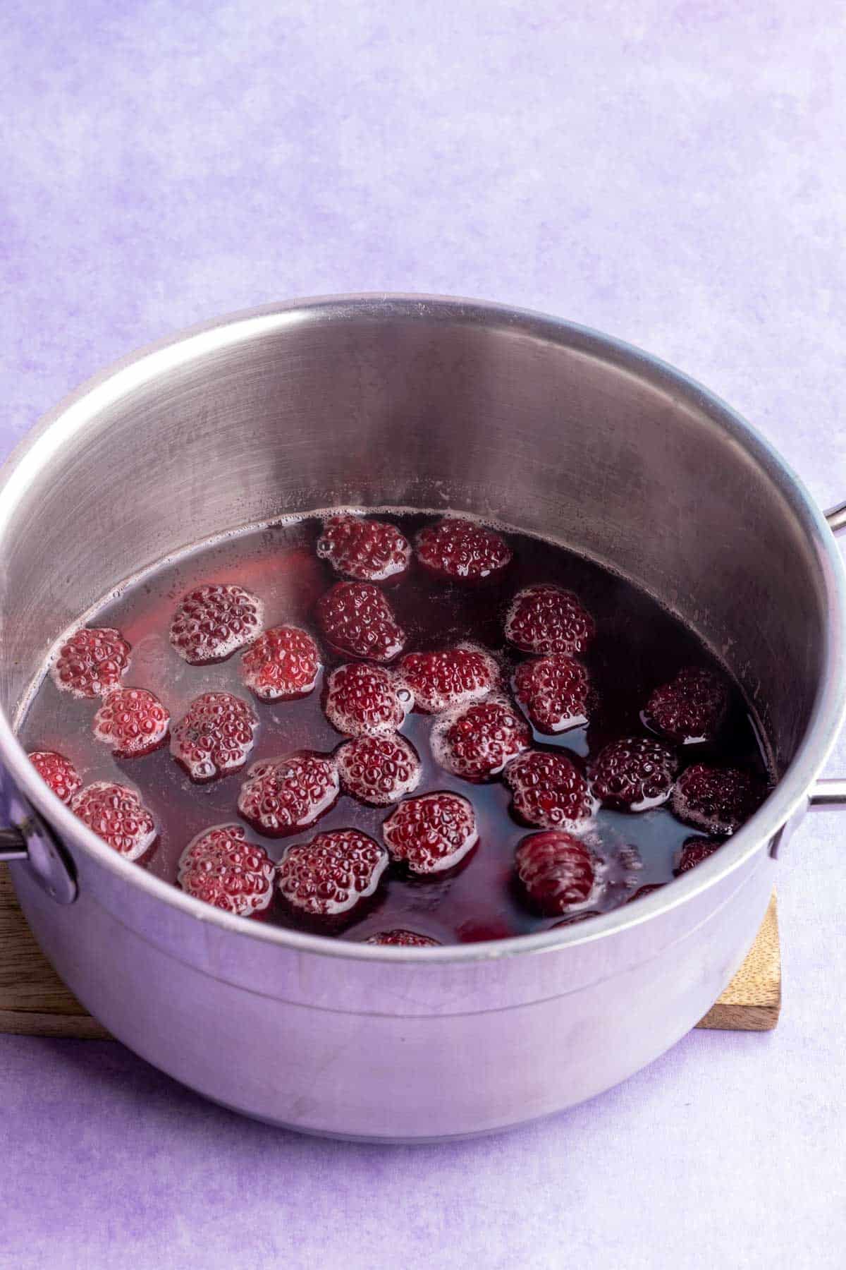 Simmering blackberry simple syrup in a pot.