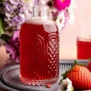 Strawberry simple syrup in syrup dispenser.