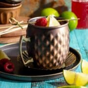 Raspberry Moscow mule with lemon wedges.