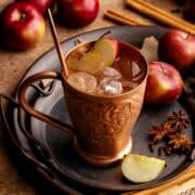Apple cider mule in a chilled copper mug with apple slice.