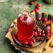 Cranberry simple syrup on metal trays with star anise and fresh cranberries.
