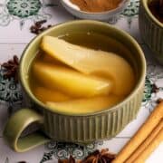 Apple and pear kompot in a large ceramic mug.