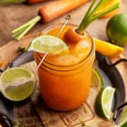 Carrot juice mocktail on a metal tray with parchment paper.